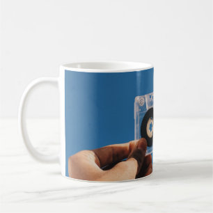 Person mit weißem Kassettenband und schwarzem Kass Kaffeetasse