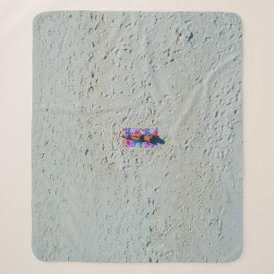Person sonnt sich am Strand Sherpadecke