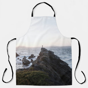 PERSON STEHEND AUF KLIFF IN DER NÄHE DES WASSERK SCHÜRZE