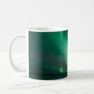 PERSON VOR POLARLICHTERN STEHEND KAFFEETASSE