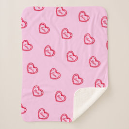 Personalisierte rote Herzen über Hübsch rosa Sherpadecke