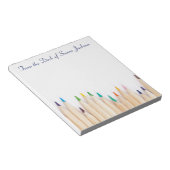 Personalisierte Stifte und vom Schreibtisch der Notizblock (angewinkelt)