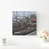 Personenzugwagen, die zur Uhr am Bahnhof eintreffe (Zuhause)