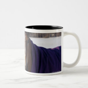 Pferd, das auf einem schneebedeckten Feld auf Zweifarbige Tasse