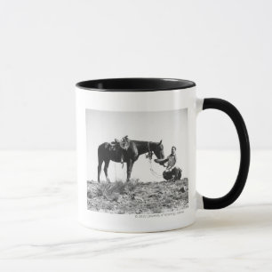 Pferd frisst aus dem Hut eines Cowboys. Tasse