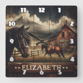 Pferde in einem rustikalen Stall unter Bergwolken Quadratische Wanduhr (Vorderseite)