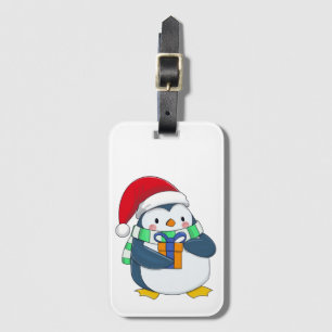 Pinguin in einem Weihnachtshut mit Geschenk Gepäckanhänger
