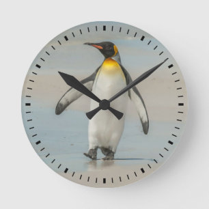 Pinguin läuft am Strand entlang Runde Wanduhr