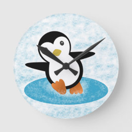 Pingüino patinando en la nieve runde wanduhr