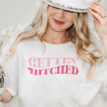 Pink Cowgirl Gettin Hitched Junggeselinnen-Abschie T-Shirt<br><div class="desc">Dieses Design enthält eine Retro-Funky-Formulierung,  die lautet: Gettin' Hitched. Ideal,  um die letzte Diskothek der Braut oder das letzte Rodeo zu feiern! Sehen Sie sich die gesamte Kollektion an,  um mehr passende Artikel zu finden!</div>
