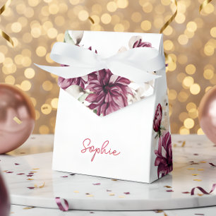 Pinkfarbene Pfingsteine auf eine bunte Geburtstags Geschenkschachtel