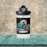 Playful Sea Otters mit Kindername Trinkflasche<br><div class="desc">Kindergröße,  klare Plastikflasche,  die das Foto von einigen Sea Otters zeigt,  die mit einem Kugelspielzeug spielen,  zusammen mit einem in weißen,  fett gedruckten Kindernamen. Personalisieren Sie die Wasserflasche,  indem Sie den Namen bearbeiten und durch den Namen des Kindes ersetzen. Wählen Sie Ihre Farbe der Wasserflasche aus.</div>