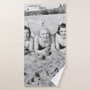 Portrait von fünf jungen Frauen, die am Strand lie Badehandtuch