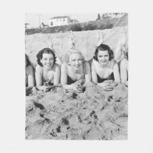 Portrait von fünf jungen Frauen, die am Strand lie Fleecedecke