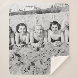 Portrait von fünf jungen Frauen, die am Strand lie Sherpadecke