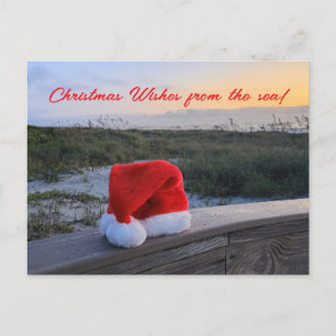 Postkarte zum Thema Strand mit Weihnachtsmannmütze