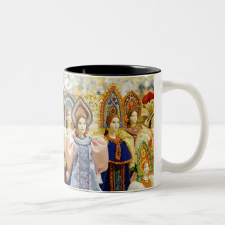 Puppen in den traditionellen russischen Kostümen Zweifarbige Tasse