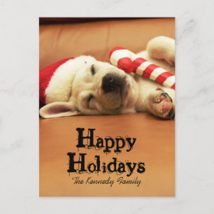 Puppy sleeps on sofa with christmas toys feiertagspostkarte