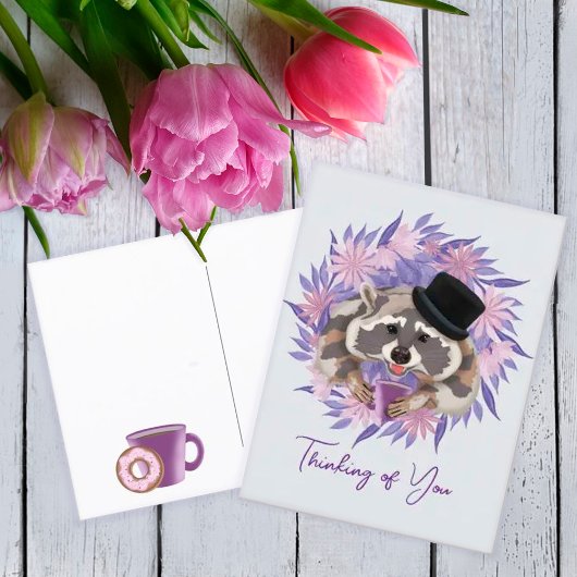 Raccoon in einem Hut mit einer Tasse Kaffee. Postkarte
