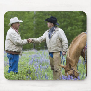 Rancher, die sich über den Zaun hinweg die Hände s Mousepad