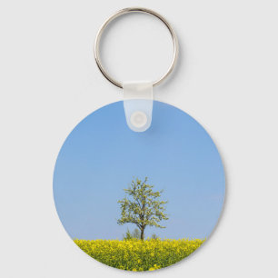 Rapsfeld mit Apfelbaum und blauem Himmel Schlüsselanhänger