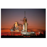 Red Sky for Space Shuttle Atlantis Start Fotoskulptur Magnet<br><div class="desc">Die knusprige Morgenluft war mit Vorfreude elektrisiert, als die ersten Morgendämmer den Himmel ein feuriges Rot malten. Die kolossale weiße Silhouette des Space Shuttle Atlantis dominierte das Launchpad, das nur durch die Unmengen des Augenblicks in den Schatten gestellt wurde. Ein kollektiver Zauber schlug sich durch die Menge, als Brandwolken aus...</div>