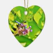 Regenbogenfarbene Libelle auf einer lila rosa Blum Keramikornament (Links)