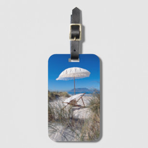Regenschirm und Stuhl auf Strand Gepäckanhänger