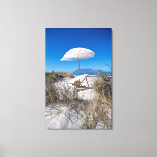 Regenschirm und Stuhl auf Strand Leinwanddruck