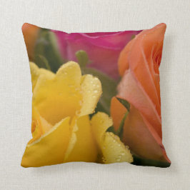 Regentropfen auf den gelb-orangeen und rosa Rosen Kissen