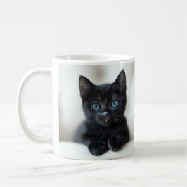 Reizendes schwarzes Kätzchen mit auffallenden blau Kaffeetasse