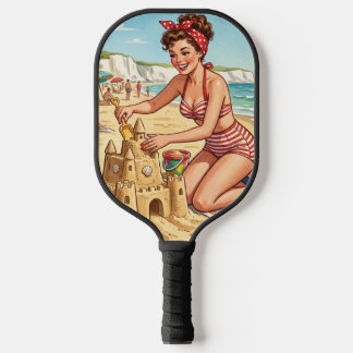 Retro-Pin-Up-Girl beim Bau einer Sandburg Pickleball Schläger
