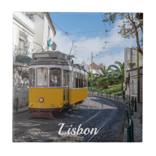Retrogelbe Straßenbahn auf einer Straße in Lissabo Fliese