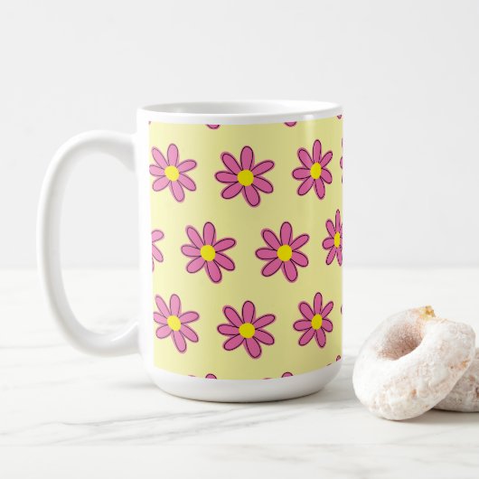 Rosa Blume auf der Tasse des Gelben Kaffees (Mit Donut)