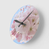 Rosa Blüten blauer Himmel. Runde Wanduhr (Winkel)