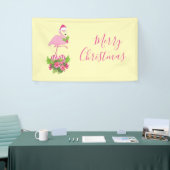 Rosa Flamingo in Weihnachtsmannmütze mit Candy Can Banner (Messeveranstaltung)