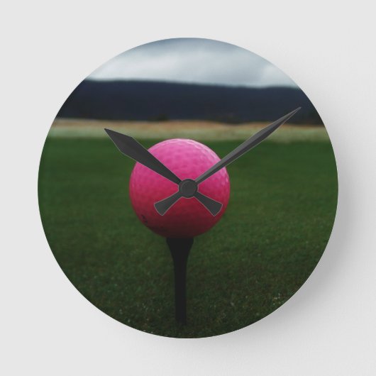 Rosa Golfball auf einem GebirgsGolfplatz Runde Wanduhr (Vorderseite)