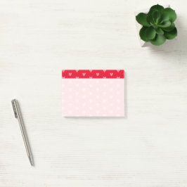 Rosa Herzen auf Rot mit ausgeblendetem Schreibbere Post-it Klebezettel
