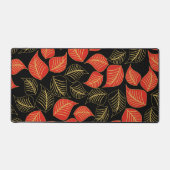 Rot und goldfarbene, breite Blätter auf schwarz Schreibtischunterlage (Vorderseite)