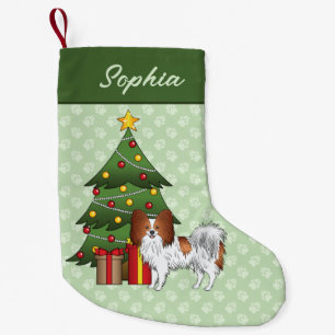 Rot-weißer Papillon-Hund an einem Weihnachtsbaum Kleiner Weihnachtsstrumpf