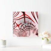 Rote, gekrümmte Spuren auf hellem Hintergrund Quadratische Wanduhr (Zuhause)