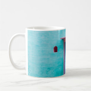 ROTE HOLZTÜR AUF BLAUE KONKRETE WAND KAFFEETASSE