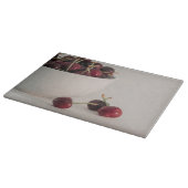 Rote Kirschfrüchte Weißschüssel in geschmeidigtem Schneidebrett (Ecke)