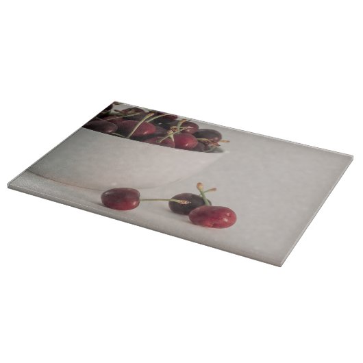 Rote Kirschfrüchte Weißschüssel in geschmeidigtem  Schneidebrett (Ecke)