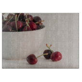 Rote Kirschfrüchte Weißschüssel in geschmeidigtem  Schneidebrett (Vorderseite)