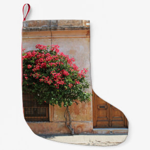 ROTE PETAL-BLUME AUF KONKRETER WAND KLEINER WEIHNACHTSSTRUMPF