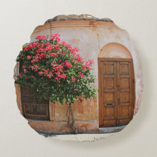 ROTE PETAL-BLUME AUF KONKRETER WAND RUNDES KISSEN
