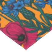 Rote Pfeffer und blaue Kornblumen auf Orange Tischdecke (Schrägansicht)