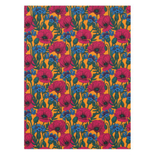 Rote Pfeffer und blaue Kornblumen auf Orange Tischdecke