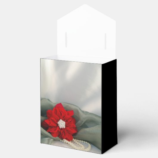 Rote Poinsettia und Perlen auf grüner Geschenkschachtel (Geöffnet)